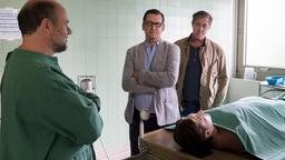 Der Pathologe Dr. Strahl (Christoph Tomanek) berichtet Lars Englen (Ingo Naujoks) und Finn Kiesewetter (Sven Martinek) von seinen Obduktionsergebnissen zur Leiche von Alexander Blohm (Daniel Axt, liegend).