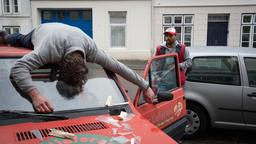 In der Lübecker Altstadt ist ein Mann aus dem Fenster gestoßen worden und landet auf dem Auto eines Fast-Food-Lieferanten (mit Komparsen).