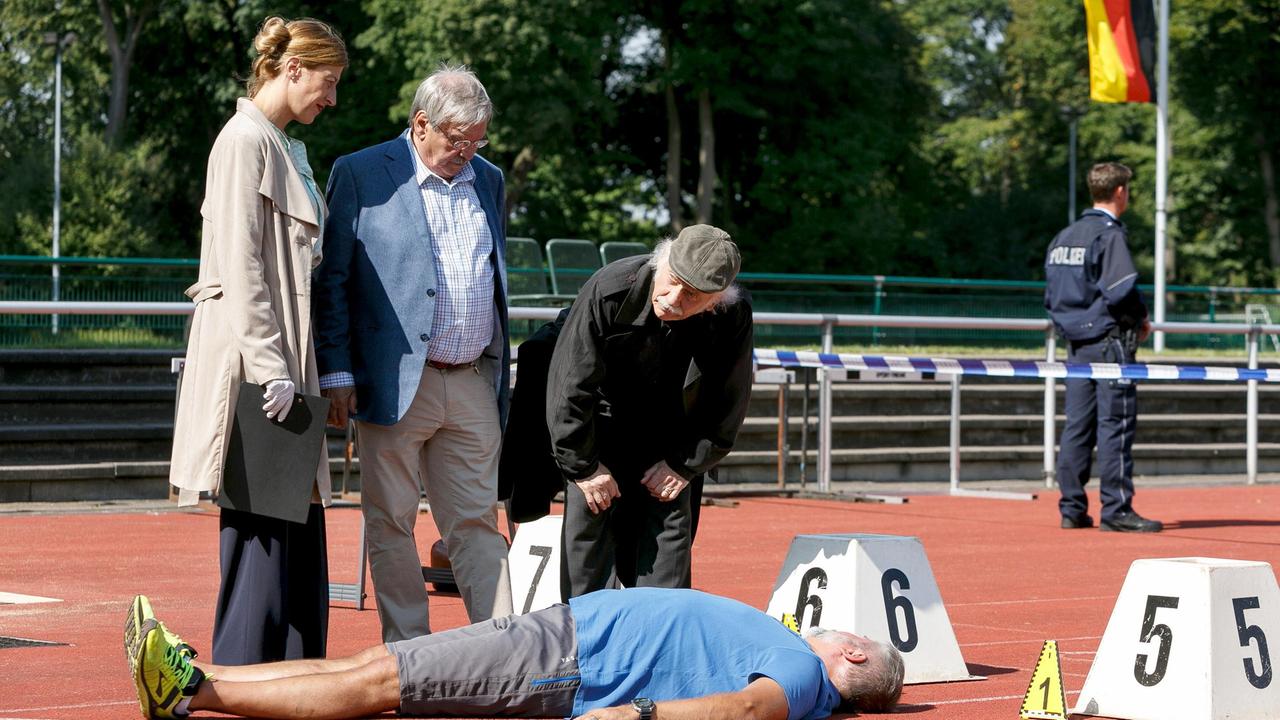  Dr. Rosalind Schmidt (Helene Grass), Edwin Bremer (Tilo Prückner) und Günter Hoffmann (Wolfgang Winkler) beugen sich über das Mordopfer Ralph Wernheim (Andreas Thürnagel)