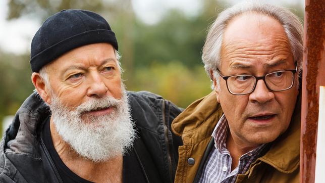 Reinhard Bielefelder (Bill Mockridge) und Klaus Schmitz (Hartmut Volle) beobachten aus einem Versteck heraus Naumann, der offensichtlich in Schwierigkeiten steckt.