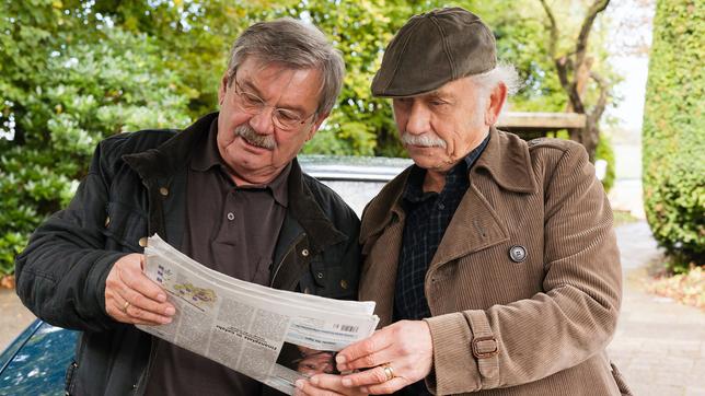 Edwin Bremer und Günter Hoffmann lesen in einer Zeitung