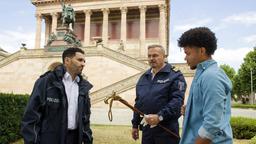 Im Kolonnadenhof der Berliner Museumsinsel konfrontieren Fahri Celik (Hassan Akkouch) und Axel Sommer (Oliver Breite) den Geschichtsstudenten Robert Baars (Nyamandi Adrian) mit der Tatwaffe, seinem Fritzstock.