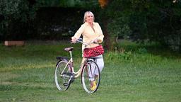 Mechthild Fehrenbach (Diana Körner) kommt mit dem Fahrrad und bringt Torte mit.