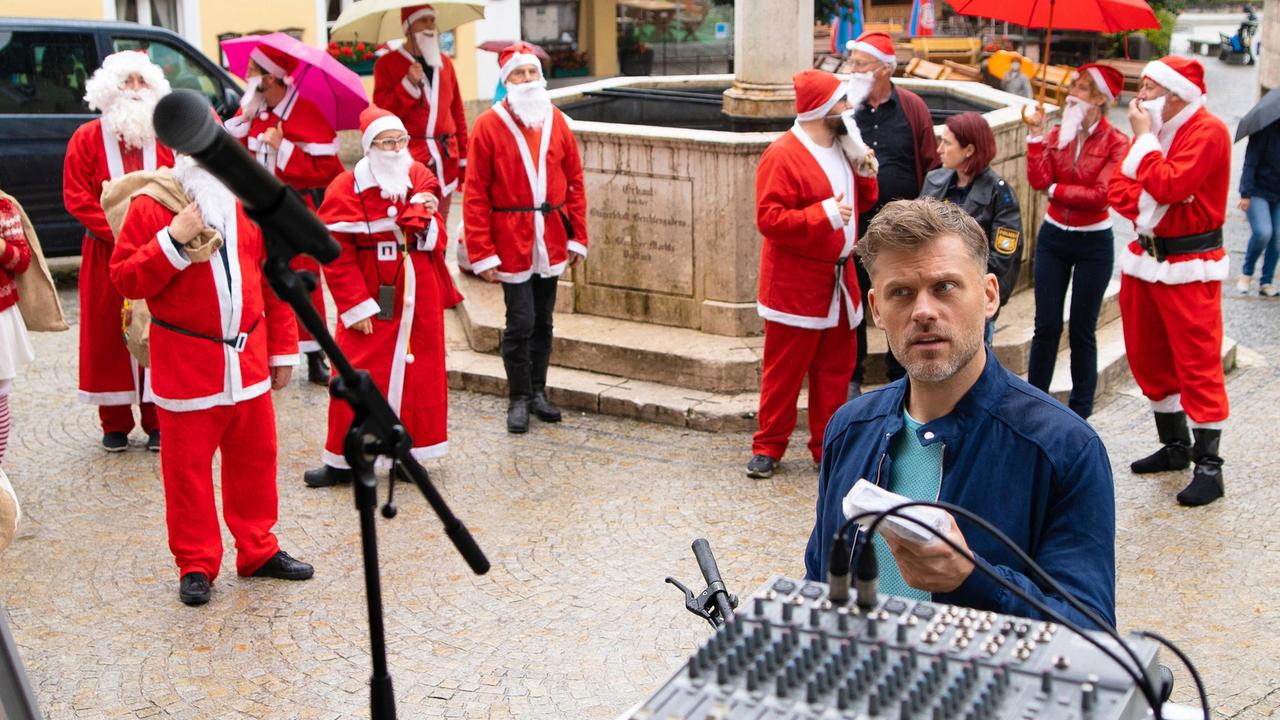 Die Berchtesgadener staunen nicht schlecht: Dutzende Weihnachtsmänner bevölkern mitten im Sommer ihr Stadtzentrum. Wer wusste von dem Flashmob? Im Bild r. vorne Pit Neumann (Jens Atzorn) und Komparsen