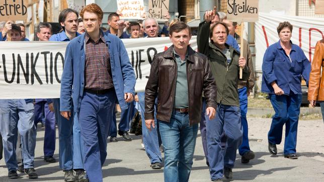 Streik im Möbelkombinat: Martin (Florian Lukas) und Maik Hüne (Aram Tafreshian) und Arbeiter.