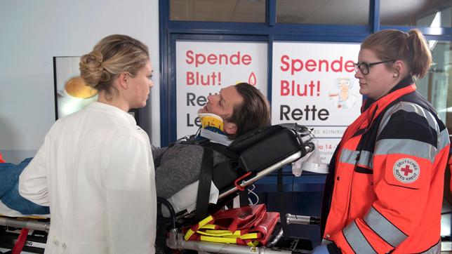 Bild: ARD/Nicole Manthey Britta (Jelena Mitschke) trifft Peer (Jörg Pintsch, M. mit Komparsin) in der Notaufnahme und erfährt, dass Sigrid bei dem Unfall schwer verletzt wurde.