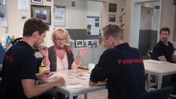 Erika (Madeleine Lierck-Wien) findet Gefallen an der Gesellschaft der Feuerwehrleute (mit Constantin Lücke, l., Mickey Hardt, r. und Komparse).