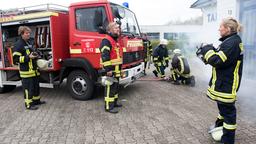 Mona (Jana Hora-Goosmann) und Ben (Hakim Michael Meziani) warten beim Feuerwehreinsatz auf Anweisungen von Einsatzleiter Jens (Martin Luding). Doch der ist wie gelähmt (mit Komparsen, h.).