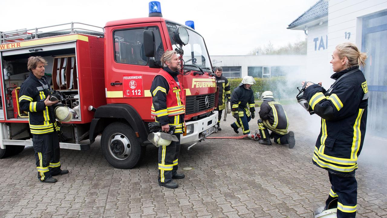 Mona (Jana Hora-Goosmann) und Ben (Hakim Michael Meziani) warten beim Feuerwehreinsatz auf Anweisungen von Einsatzleiter Jens (Martin Luding). Doch der ist wie gelähmt (mit Komparsen, h.).