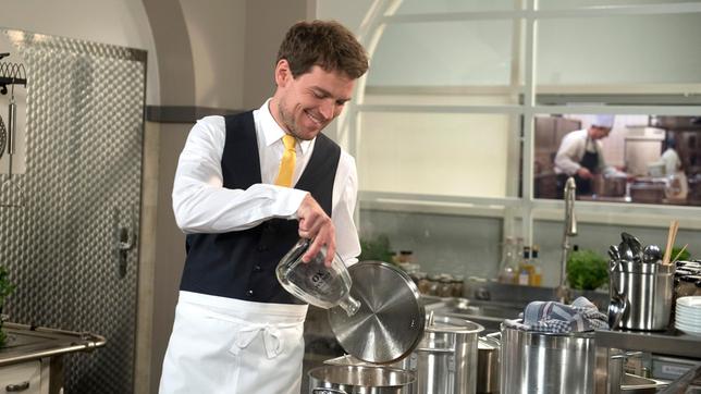 Bild: ARD/Nicole Manthey Patrick (Constantin Lücke) schüttet heimlich Alkohol in die Rouladen-Sauce, um Gunters Stellung vor den Angestellten zu schwächen.