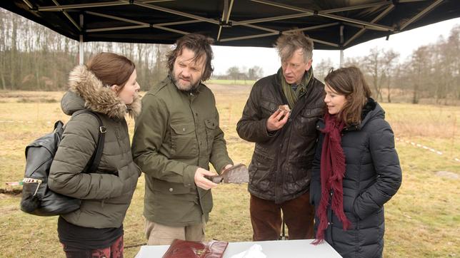 Swantje (Malin Steffen) und Helen (Patricia Schäfer) freuen sich für Arne (Christian Rudolf), als Dr. Busch (Martin Horn) seine Varusschlacht-Hypothese bekräftigt.