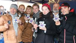 Sturm der Liebe Weihnachtsmarkt 2015 München Sendlinger Tor: Joachim Lätsch (l.), Michael Sandorov (2.v.l.), Mona Seefried (3.v.l.), Niklas Löffler (M.), Christin Balogh (3.v.r.) und Michael Kühl (r.) mit einem Mitarbeiter der Münchner Aids-Hilfe