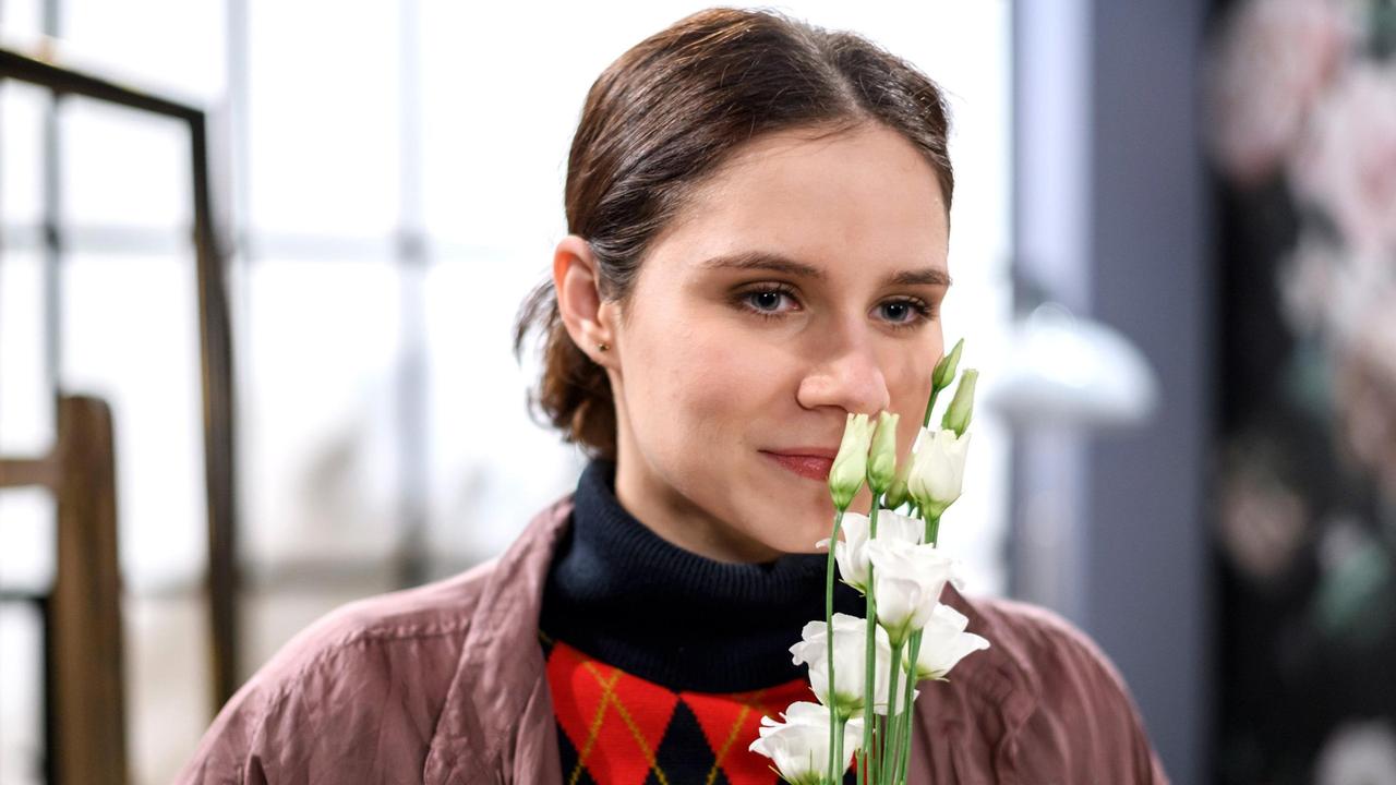 Denise (Helen Barke) freut sich über die Blumen von Henry.