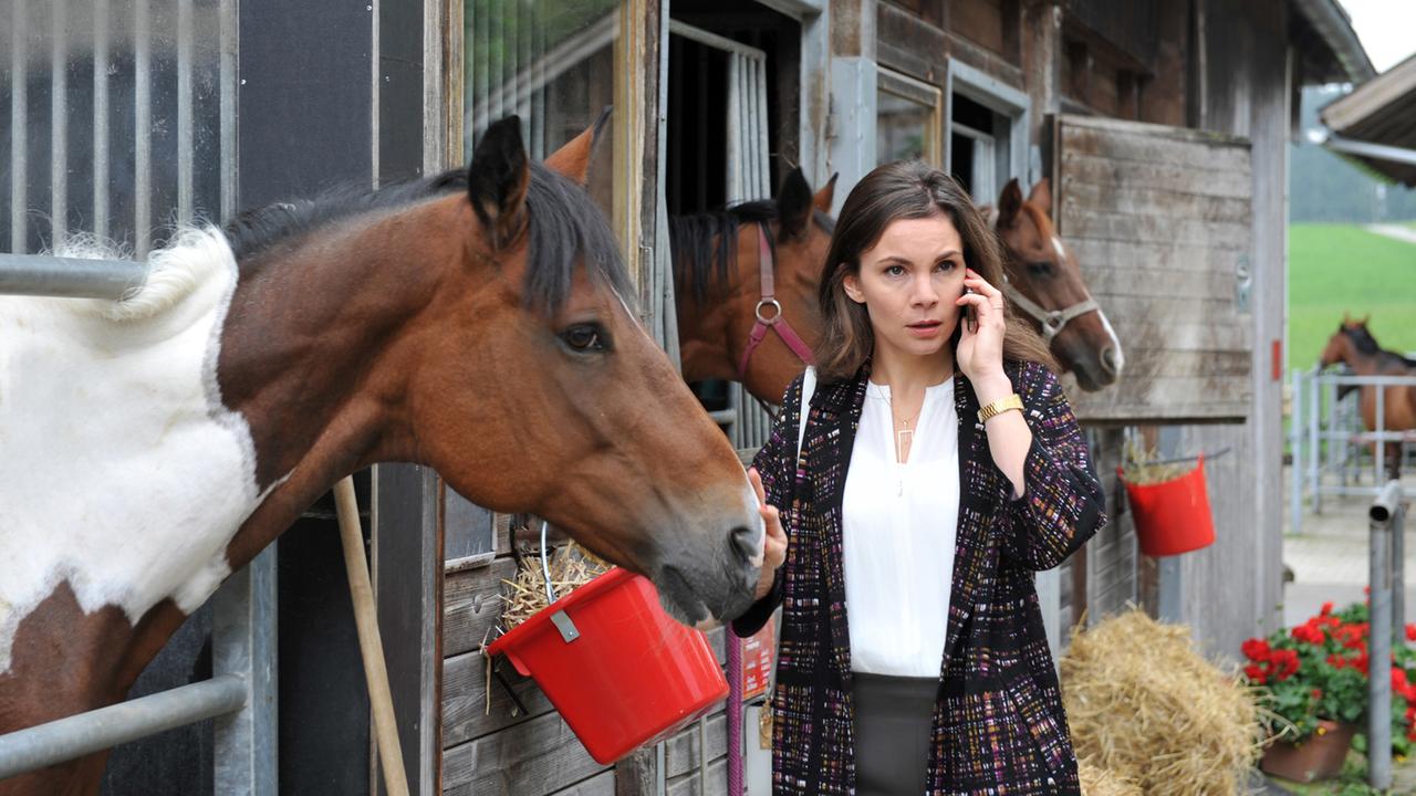 Sturm der Liebe Folge 2105: Patrizia mit Handy vor dem Pferdestall