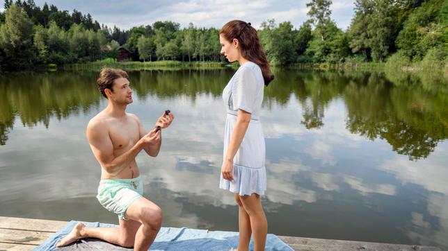 Joshua (Julian Schneider) macht Denise (Helen Barke) einen romantischen Heiratsantrag am See.