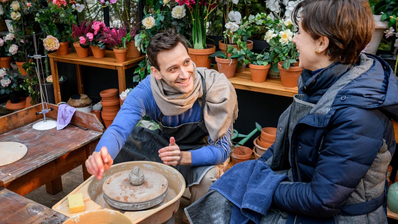 Julian (Tim Borys, l. mit Dorothée Neff) stellt sich humorvoll der Herausforderung an der Töpferscheibe.