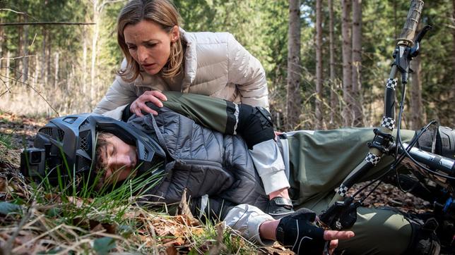 Lia (Deborah Müller, h.) muss entsetzt mit ansehen, wie Benni (Florian Burgkart) beim Mountainbiken stürzt.