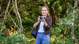 Maja (Christina Arends) genießt es im Bannwald fotografieren zu dürfen - und bemerkt dabei nicht, dass sie den Deckel eines Filmdöschens verliert ...