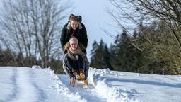 Maja (Christina Arends) und Florian (Arne Löber) machen auf ihrem Heimweg von der Almhütte eine Schlittenfahrt.