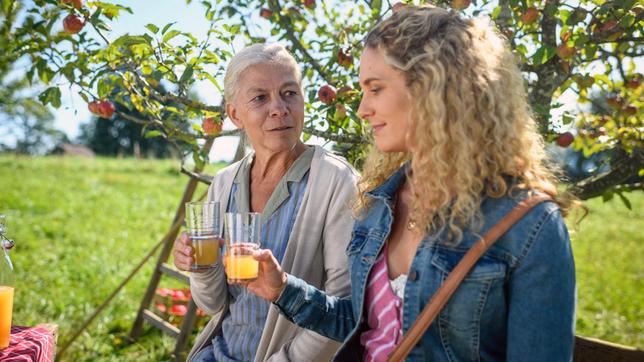 Margit (Michaela Stögbauer) und Franzi (Léa Wegmann) trösten sich gegenseitig bei einem Glas selbst gemachten Apfelsaft.