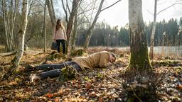 Nadja (Anna Lena Class, h.) findet den regungslosen Dirk (Markus Pfeiffer) im Wald.