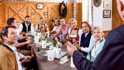 Natascha (Melanie Wiegmann), Michael (Erich Altenkopf) und Hildegard (Antje Hagen) lauschen gespannt, als Alfons (Sepp Schauer) den Namen der schönsten Bäuerin Oberbayerns verkündet (mit Komparsen).