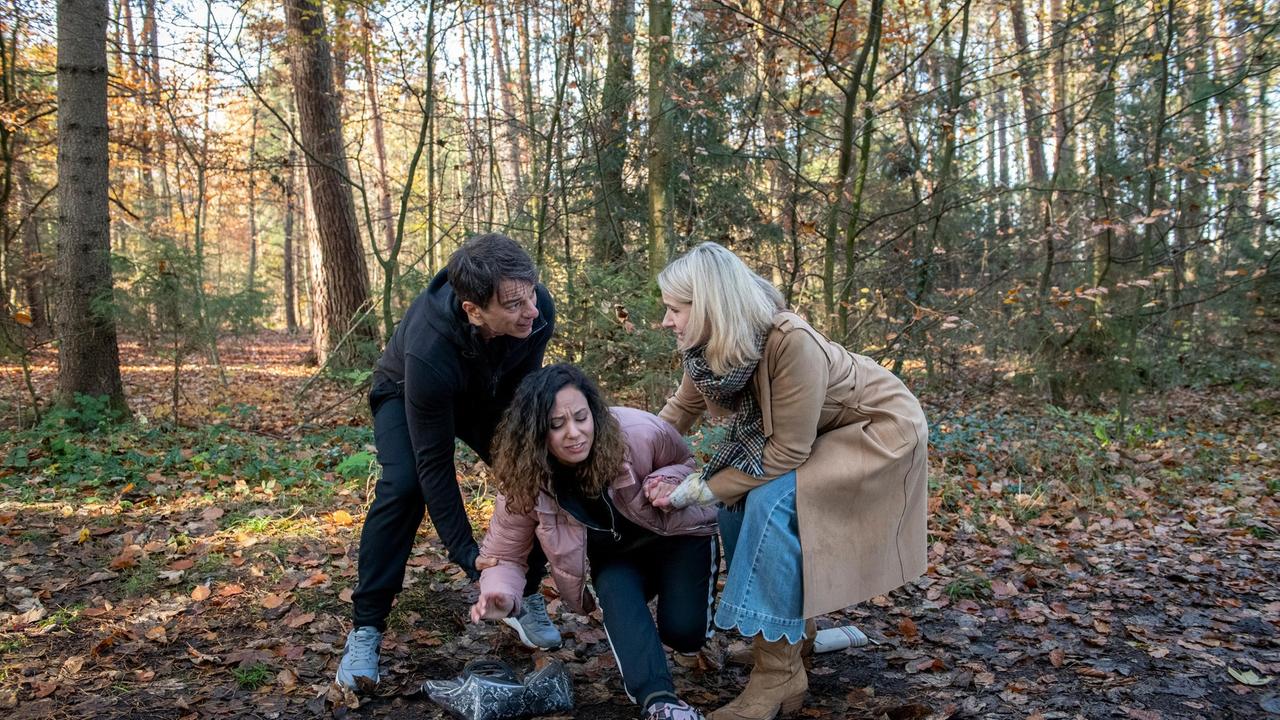 Vanessa (Jeannine Gaspár) hat starke Schmerzen im Knie und muss von Robert (Lorenzo Patané) und Amelie (Julia Gruber) gestützt werden.